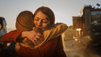 Woman with injuries on her face hugging a girl